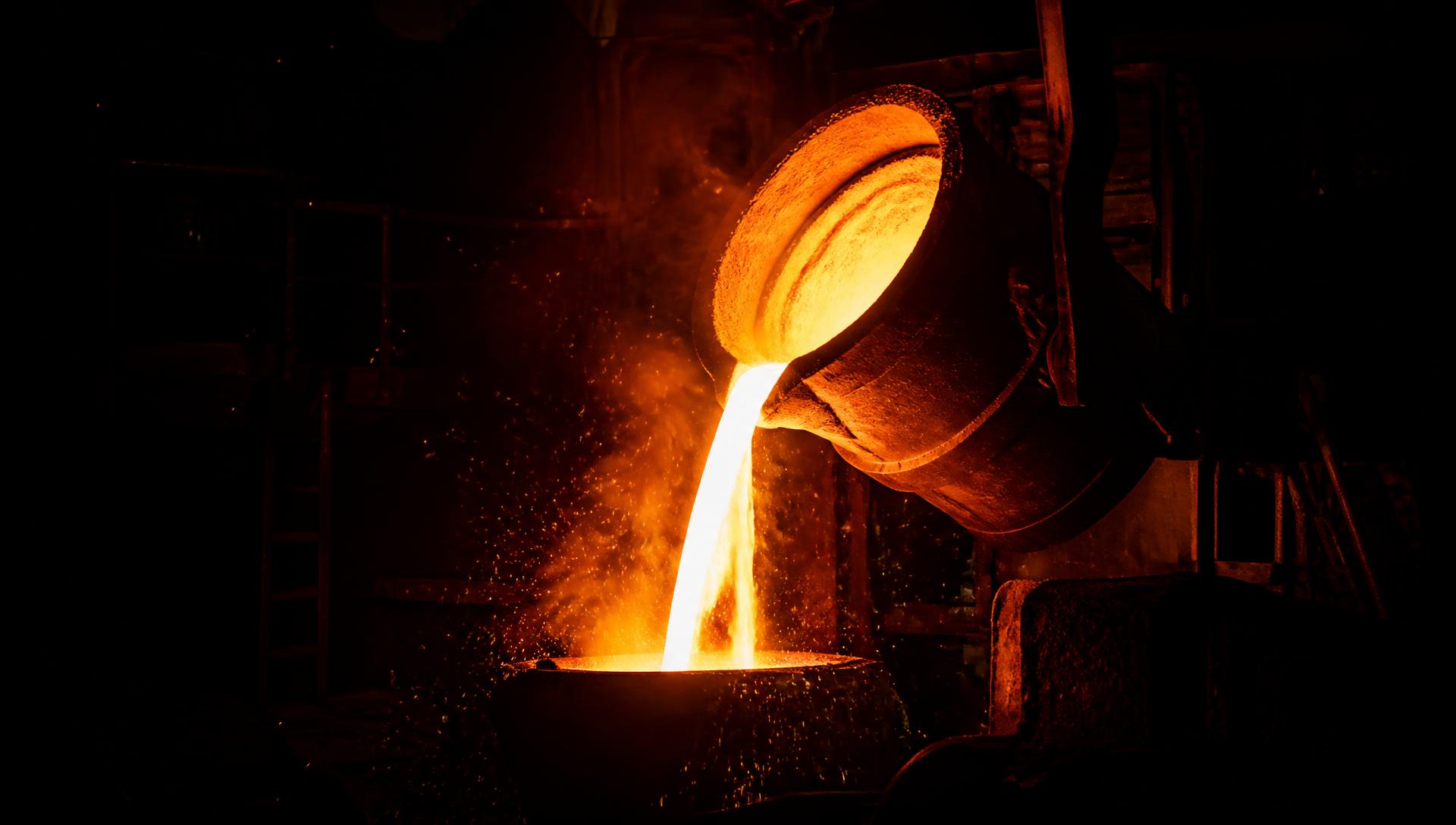 Molten metal pouring from a ladle, incandescent material carrying the cumulative exergy destroyed to produce it.