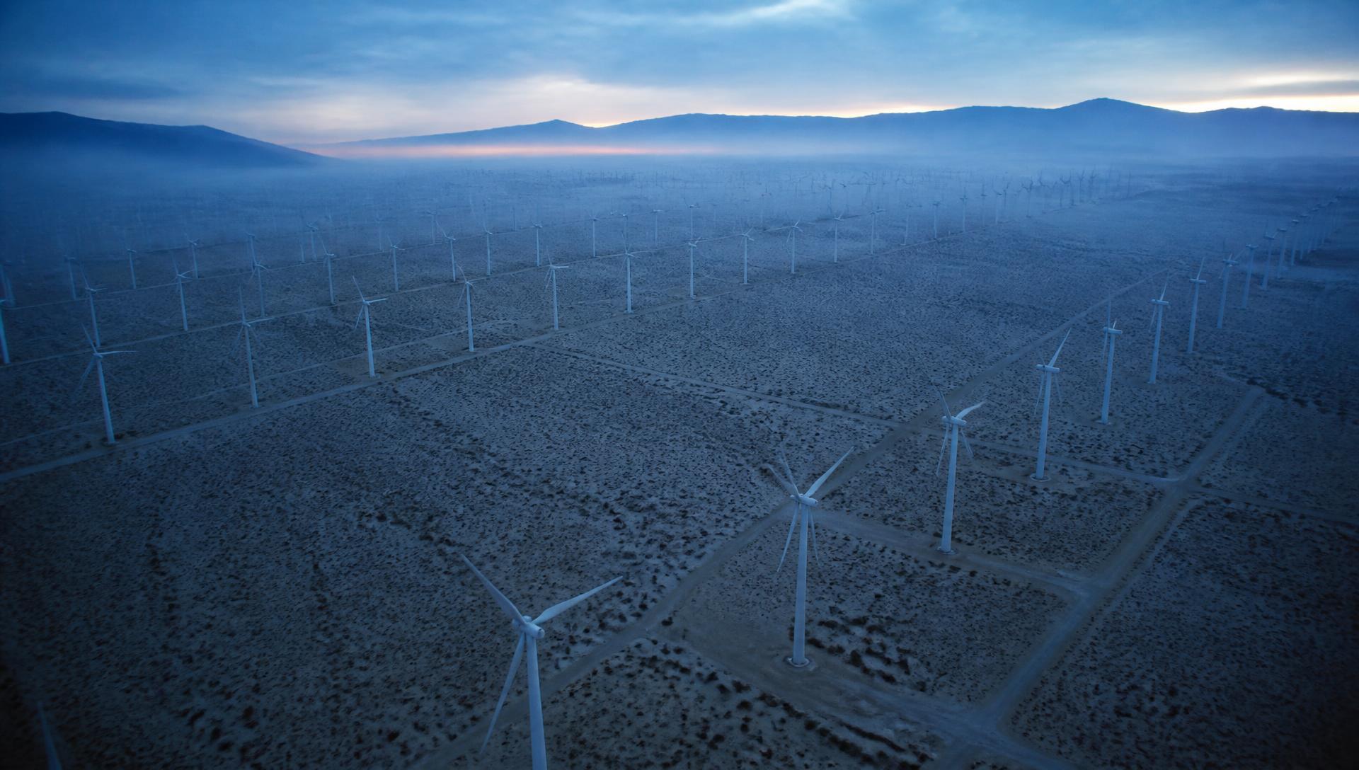 Wind turbine array at cold dawn seen from altitude, a vast conversion of atmospheric exergy into shaft work.