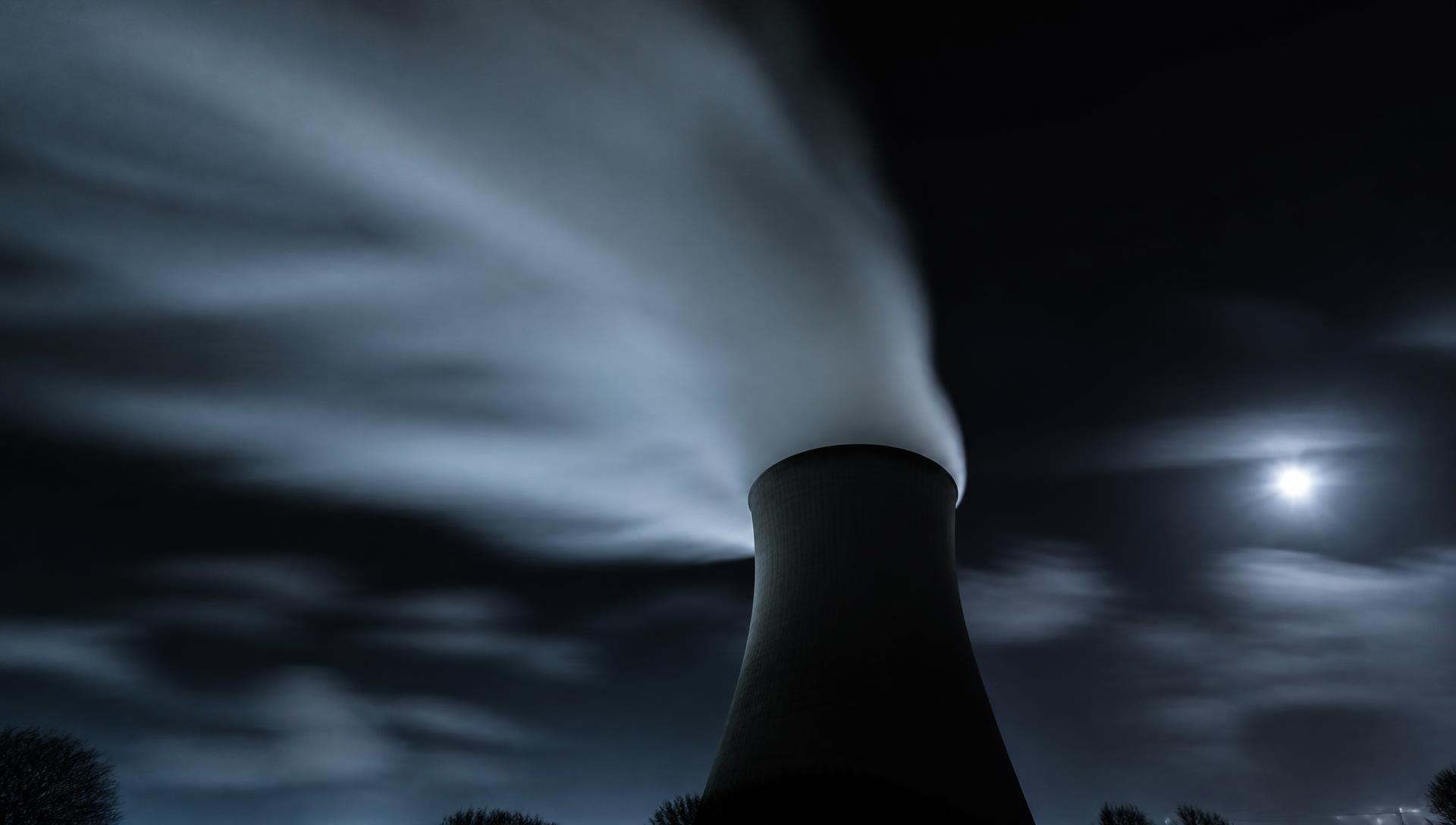 Cooling tower plume rising at night, low grade heat rejected to the surroundings after its exergy has been spent.
